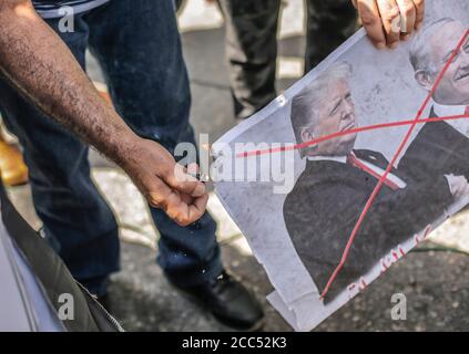 Gaza-Stadt, Der Gazastreifen, Palästina. August 2020. Ein palästinensischer Demonstranten brennt ein Bild, das US-Präsident Donald Trump während eines Protestes gegen den Deal der Vereinigten Arabischen Emirate mit Israel zur Normalisierung der Beziehungen in Gaza City am 19. August 2020 darstellt. Kredit: Mahmoud Issa/Quds Net Nachrichten/ZUMA Wire/Alamy Live Nachrichten Stockfoto