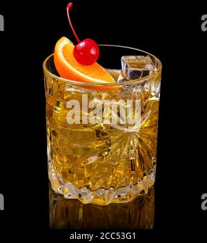 Whiskey-Cocktail garniert mit Orange und Kirsche isoliert auf schwarz Stockfoto