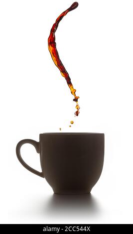 Kaffeespritzer fliegen über eine hinterleuchtete Tasse isoliert auf weiß Stockfoto