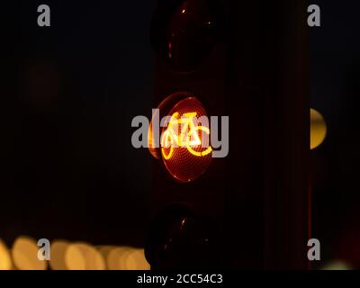 Ampel für Fahrräder in der Nacht. Orangefarbenes, gelbes Licht für Sportkonzept. Gesundes Leben Stockfoto