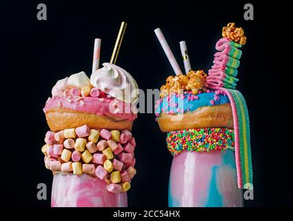 Nahaufnahme von zwei Freak-Shakes auf schwarzem Hintergrund Stockfoto