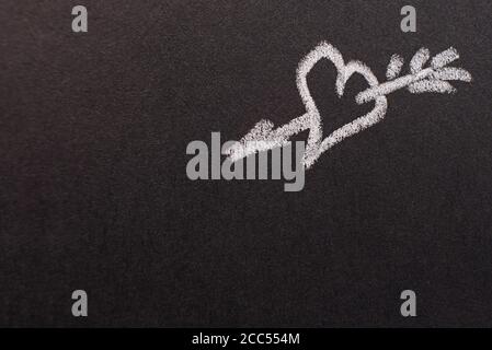 Handgezeichnetes Herz mit Pfeil auf schwarzem Kreidetafel. Kopierraum. valentinstag, alle Liebhaber Konzept Stockfoto