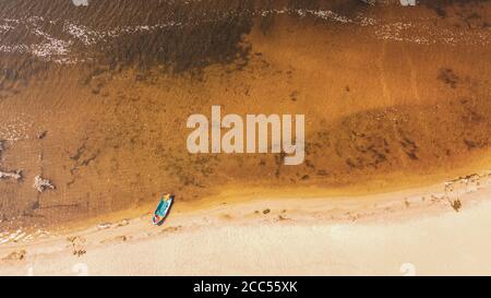 Luftaufnahme der Küste. Sommerseekape mit klarem Wasser an sonnigen Tagen. Draufsicht auf das Boot von der Drohne. Stockfoto