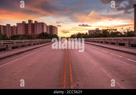 Mitten auf der Straße Überführung auf Bluebill Avenue in Richtung Delnor Wiggins State Park bei Sonnenuntergang in Naples, Florida. Stockfoto