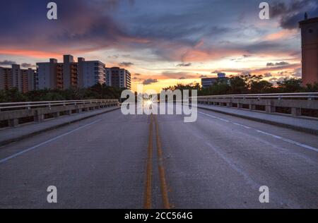 Mitten auf der Straße Überführung auf Bluebill Avenue in Richtung Delnor Wiggins State Park bei Sonnenuntergang in Naples, Florida. Stockfoto