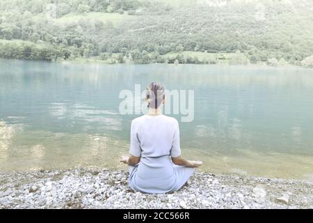 Frau beim Yoga vor einem spektakulären Bergsee Stockfoto