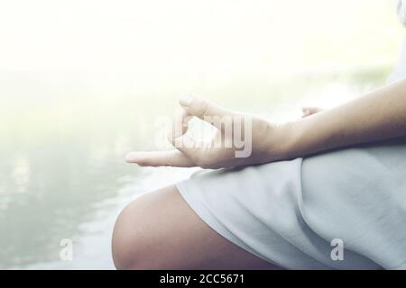 Frau macht Yoga-Übungen vor einem spektakulären Berg see Stockfoto