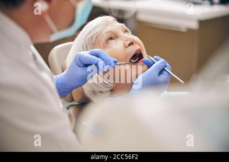 Ältere Frau mit ihren Zähnen Untersuchung in der Kieferorthopädie Stockfoto