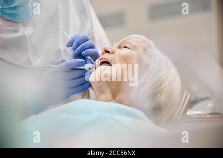 Zahnarzt Behandlung der Patientin mit der Bohrmaschine auf Ihren Zähnen Stockfoto