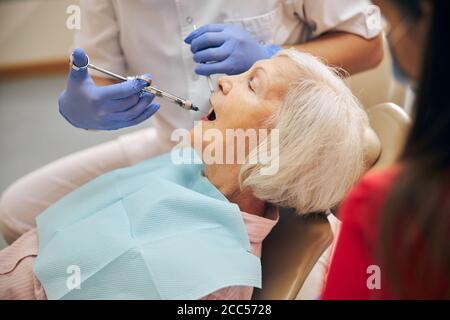 Arzt macht Injektion an weibliche Besucher in der Zahnklinik Stockfoto