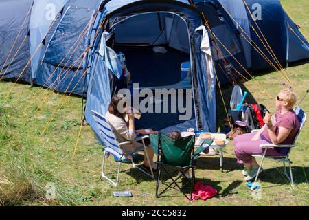 2 Frauen und Kind sitzen draußen auf dem Campingplatz Stockfoto