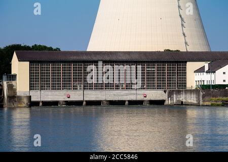 Drei Schleusen eines Wasserkraftwerks mit Maschinenhaus. Und im Hintergrund ein Kühlturm eines Kernkraftwerks. Stockfoto