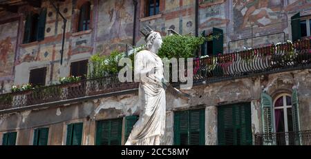 Der Brunnen der Madonna von Verona in Piazza Erbe, mit bemalten Fassaden auf den Gebäuden dahinter, ein charakteristisches Merkmal der Altstadt. Stockfoto