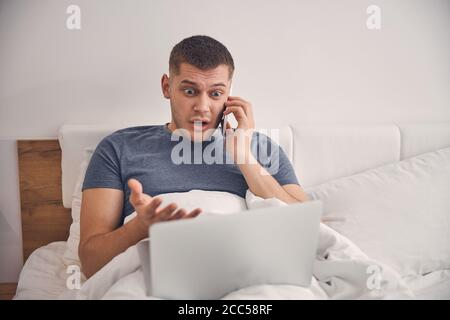 Attraktive männlich aussehende Angst während des Aufenthalts im Schlafzimmer Stockfoto