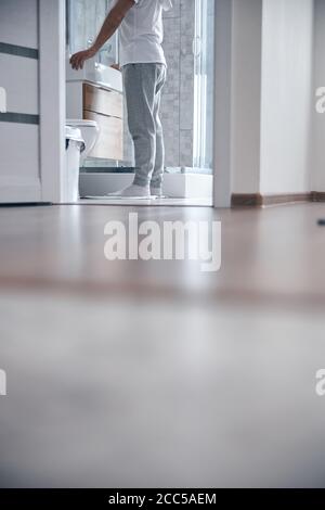 Männchen in Socken, die auf der Badematte stehen Stockfoto