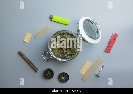 Draufsicht auf Cannabisrauchersachen. Marihuana und Papier auf grauem Hintergrund Stockfoto