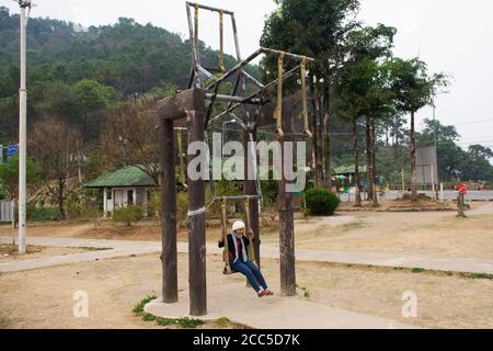 Reisende thai Frauen sitzen spielen große hölzerne Schaukel am Aussichtspunkt Von Pang Ma Pha Scenic Point und Luk Khao Lam Aussichtspunkt mit Nebel oder Nebel am Morgen Stockfoto