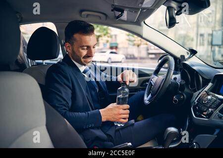 Hübscher junger Geschäftsmann, der in seinem Auto sitzt Stockfoto