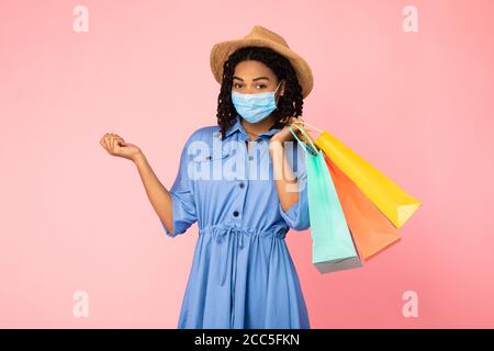 African American Girl Auf Shopping Trägt Gesichtsmaske, Rosa Hintergrund Stockfoto