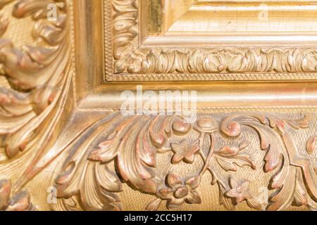 Nahaufnahme von rustikalem Baguette des Gemäldes. Gold geschnitzte Blumen und Blätter Stockfoto