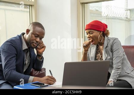 Junge afrikanische Geschäftsmann und Frau fühlen sich in einem Treffen gelangweilt Stockfoto