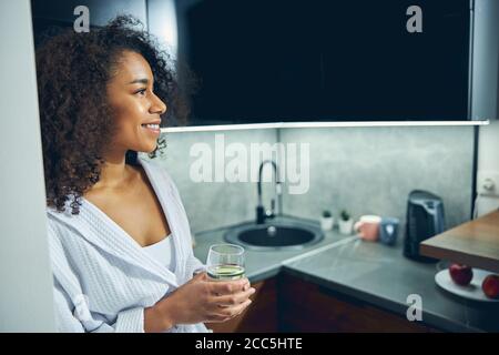 Fröhliche junge Frau, die in der Küche steht Stockfoto
