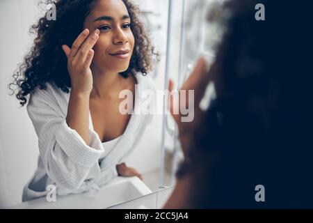 Schöne Frau starrte sich im Spiegel an Stockfoto