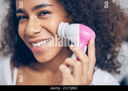 Dunkelhaarige Frau mit einem Peeling-Pflegemittel Stockfoto