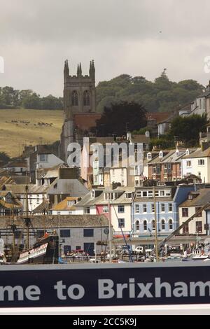 Brixham, South Devon, UK zeigt St. Mary's Church Turm, inneren Hafen und bunte Häuser auf dem Hügel Stockfoto