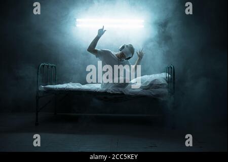 Psycho Mann mit verbundenen Augen im Bett sitzen, Krankenhaus Stockfoto