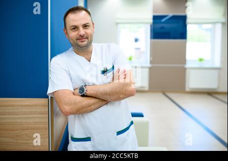 Freundlicher männlicher Arzt im Klinikkorridor Stockfoto