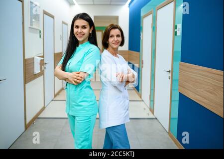 Lächelnde Ärztinnen posiert im Klinikkorridor Stockfoto