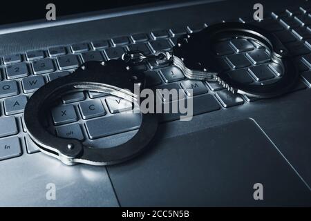 internet-Betrug Cyber-Kriminalität Konzept - Handschellen auf Laptop keybpord Stockfoto