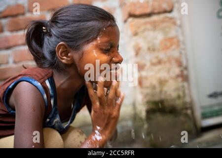 Anu Kumari (10) wäscht ihr Gesicht mit Wasser aus dem neuen Wasserhahn, den ihre Mutter vor kurzem im Haus der Familie in Bihar, Indien, installiert hatte. Die meisten Menschen im ländlichen Indien können kein Wasser in ihrem eigenen Haus laufen lassen, aber die Beteiligung der Familie Anand an Partnership Bihar hat ihren Lebensstandard erheblich erhöht. Partnership Bihar ist eine lutherische Weltenhilfe-Initiative, die bessere Anbaumethoden, hochwertiges Saatgut, verbesserte Ernährung für Familien und Selbsthilfegruppen für Mikrofinanzierungen in Gemeinden in einem der ärmsten indischen Staaten bringt. Pradan (Professionelle Hilfe für Entwicklung Stockfoto