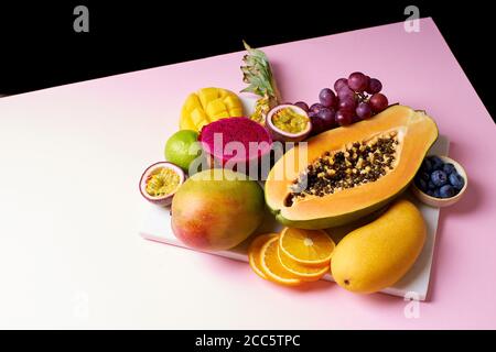 Tropische Früchte Stillleben mit Mango, Papaya, Pitahaya, Passionsfrucht, Trauben, Limette und Ananas. Obstteller Stockfoto