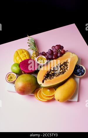 Tropische Früchte Stillleben mit Mango, Papaya, Pitahaya, Passionsfrucht, Trauben, Limette und Ananas. Obstteller Stockfoto
