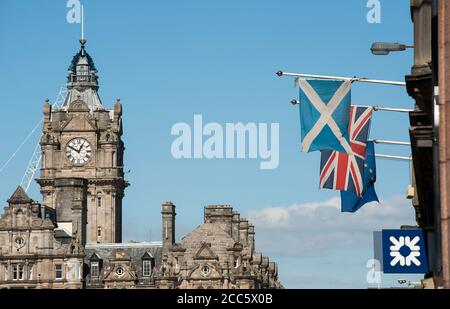 Flaggen fliegen vor einem Gebäude auf dem Lawnmarket in der Stadt Edinburgh, Schottland. Stockfoto