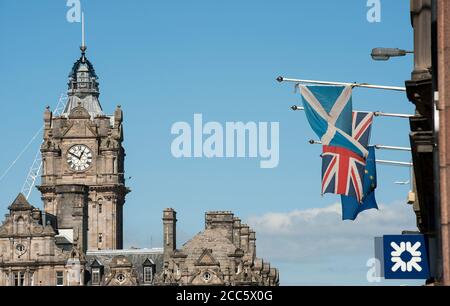 Flaggen fliegen vor einem Gebäude auf dem Lawnmarket in der Stadt Edinburgh, Schottland. Stockfoto