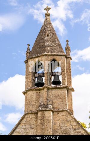 Bellcote aus dem 13. Jahrhundert mit zwei spitzen Glockenkammern auf dem Westgiebel der Kirche St. Oswald im Cotswold-Dorf Shipton Oliffe, Glos. Stockfoto