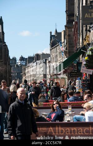 Menschen essen außerhalb Restaurants auf der Royal Mile, Edinburgh, Schottland. Stockfoto