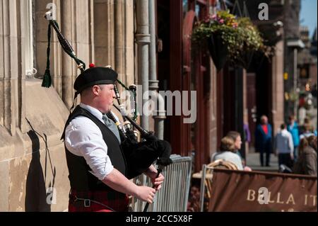 Dudelsack-Spieler in traditioneller schottischer Tartan, der auf der Royal Mile in Edinburgh, Schottland, Dudelsack spielt. Stockfoto