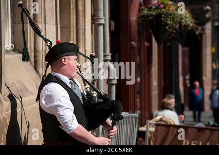 Dudelsack-Spieler in traditioneller schottischer Tartan, der auf der Royal Mile in Edinburgh, Schottland, Dudelsack spielt. Stockfoto