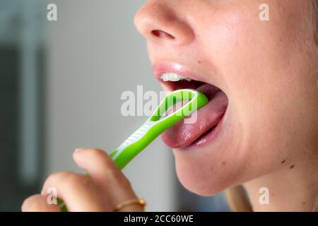 Mundgeruch, Vorbeugung durch Reinigung der Zunge mit einer Zungenbürste Stockfoto