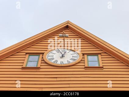 BERGEN NORWEGEN - 2016. MAI 01. Wunderschöne Uhr im Freien auf dem orangefarbenen Woddenhaus. Stockfoto