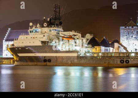 BERGEN, NORWEGEN - 2015. DEZEMBER 23. Anchor Handling Schlepper AHTS Olympic Hercules im Hafen von Bergen mit Langzeitaufnahme Stockfoto