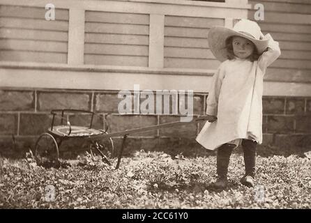 Ein nettes kleines Mädchen mit Cowboy Hut hält Waggonzunge. Stockfoto