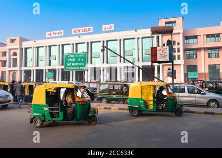 NEW DELHI, INDIEN - 12. FEBRUAR 2014: Menschen und Rikschas in der Nähe des Bahnhofs von Neu Delhi Stockfoto