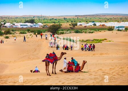 JAISALMER, INDIEN - 13. OKTOBER 2013: Unidentififizierte Menschen und Kamele auf Safari in der Thar Wüste nahe Jaisalmer Stadt in Indien Stockfoto