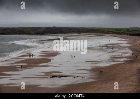 Tenby, Pembrokeshire, West Wales. August 2020. Panorama mit Blick auf einen grauen, teilweise menschenleeren Strand, während Spaziergänger einen Spaziergang zwischen Regen und Wind am Strand von Tenby, West Wales, machen, an einem Sommertag, an dem Stoms und schlechtes Wetter Südengland und West Wales, Großbritannien, heimgesucht haben. Mittwoch, 19. August 2020. Tenby, Pembrokeshire, West Wales, UK Credit: Jeff Gilbert/Alamy Live News Credit: Jeff Gilbert/Alamy Live News Stockfoto