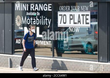 70 Platte neue Auto Werbung Mann trägt Gesichtsmaske in Douglas Park Mini Händler Garage Fenster während Coronavirus Pandemie, Glasgow, Schottland, Großbritannien Stockfoto